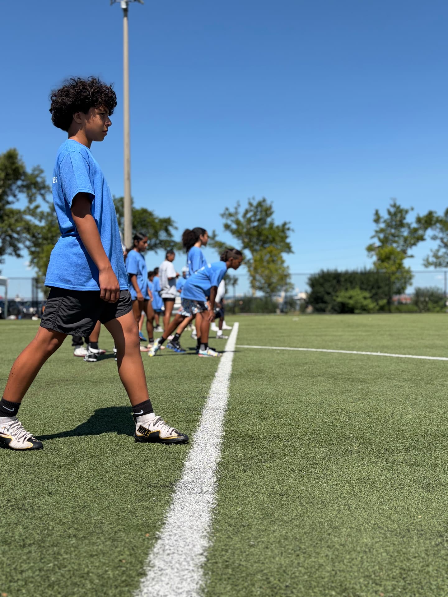 Campers lined up on the field line before a drill